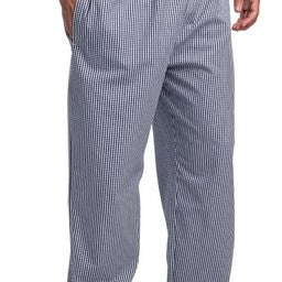 Horecamedewerker in zwarte stretchbroek met rechte pijp, staand in een restaurantkeuken tijdens de voorbereiding.