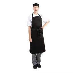 Bedieningsmedewerker met zwart halterschort en wit overhemd, klaar om te serveren op een sfeervol restaurantterras.
